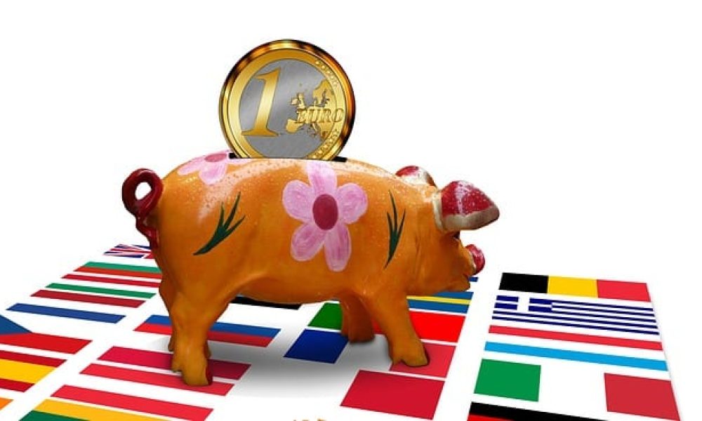 Sparschwein mit Euro stehend auf Flaggen europäischer Länder
